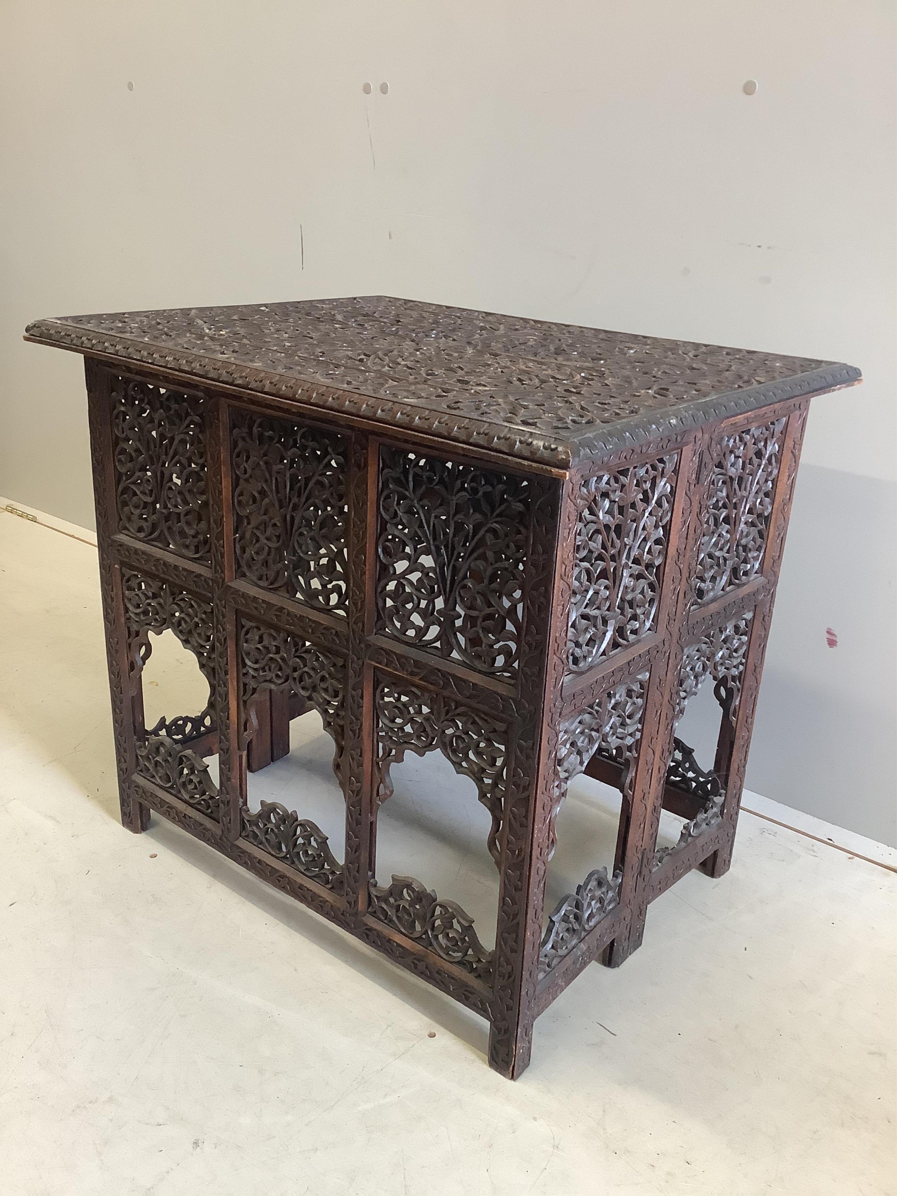 A late 19th century Burmese carved teak folding table, width 69cm, depth 55cm, height 163cm